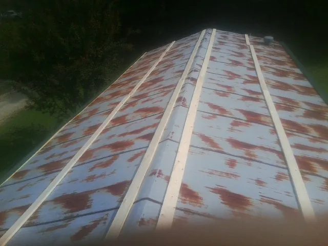 Rusted metal roof panels with new wood purlins before replacement — Storm Damage Roof Repair in Crowley by Roofing Brothers
