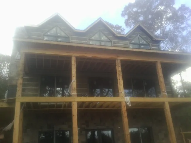 Dormers and porch framing on a large log home under construction in Crowley